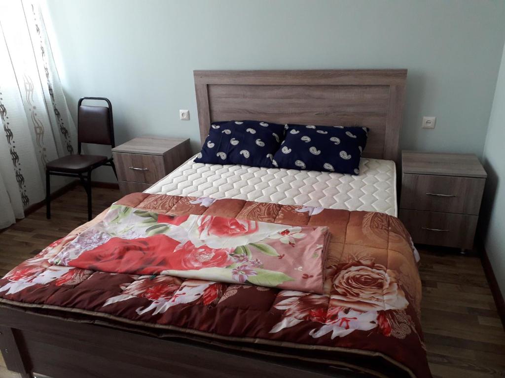 um quarto com uma cama com colcha floral em квартира em Batumi