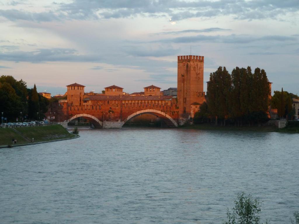 un puente sobre un río frente a un edificio en Casa Archi - Vista sul Fiume en Verona
