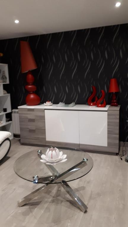 um quarto com uma mesa de vidro com sapatos vermelhos numa prateleira em 25 Rue Raymond Braillard em Dole