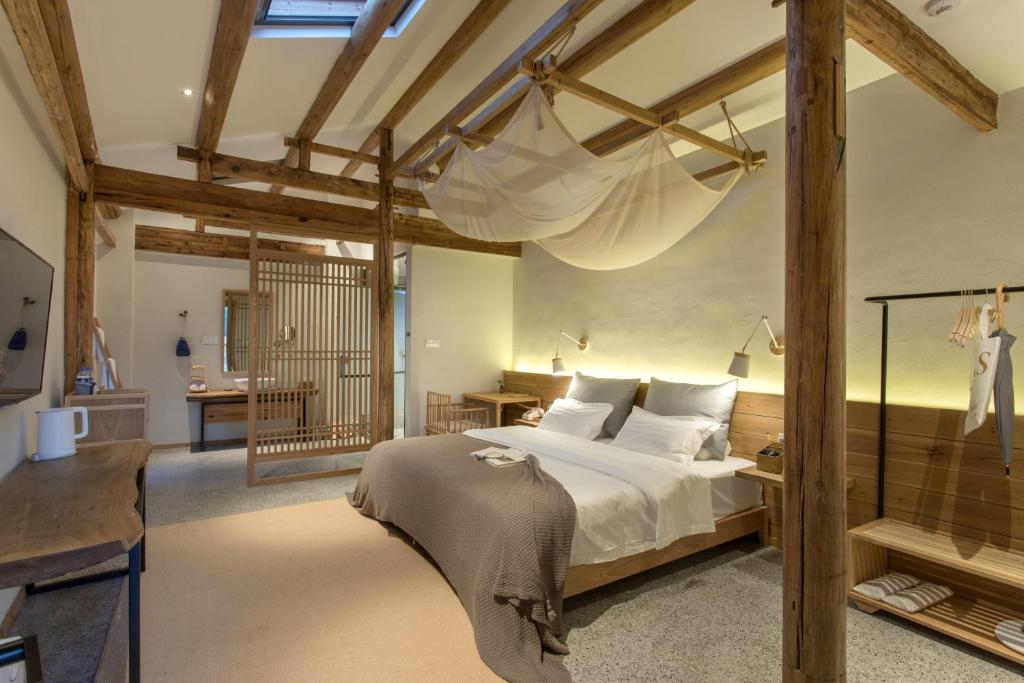 a bedroom with a large bed with a large chandelier at Hongcun old street Country House in Huangshan