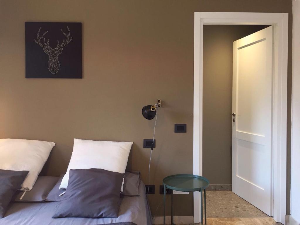 a bedroom with a bed and a table next to a door at Il Contrabbasso in Cremona