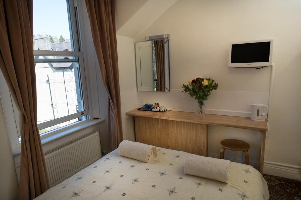 - une petite chambre avec un lit et une fenêtre dans l'établissement Somerset House B&B, à Grange-over-Sands