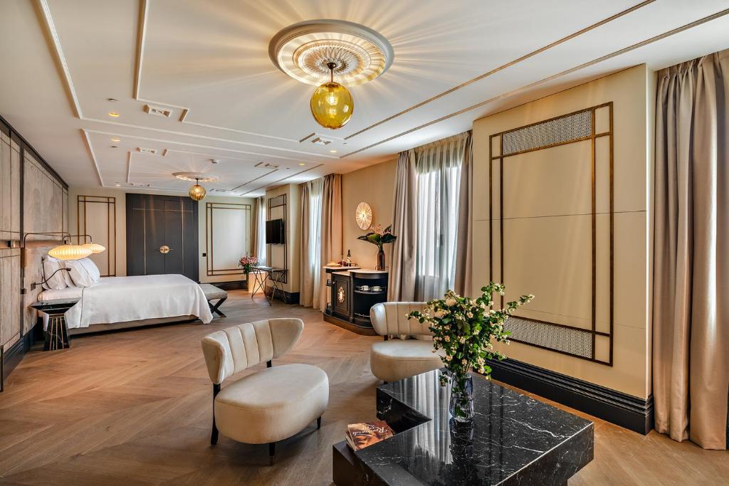 マドリードにあるCoolRooms Palacio de Atochaのベッドとリビングルームが備わるホテルルームです。