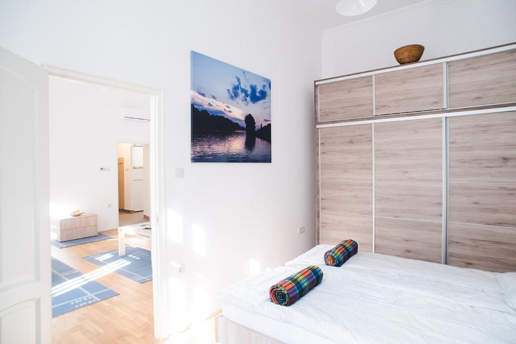 ブダペストにあるRégiposta street 2 - City centerの白いベッドと木製の壁が備わるベッドルーム1室が備わります。