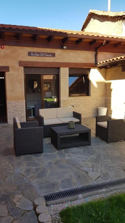 a patio with couches and tables in front of a building at La Casina del Cerecedo in León