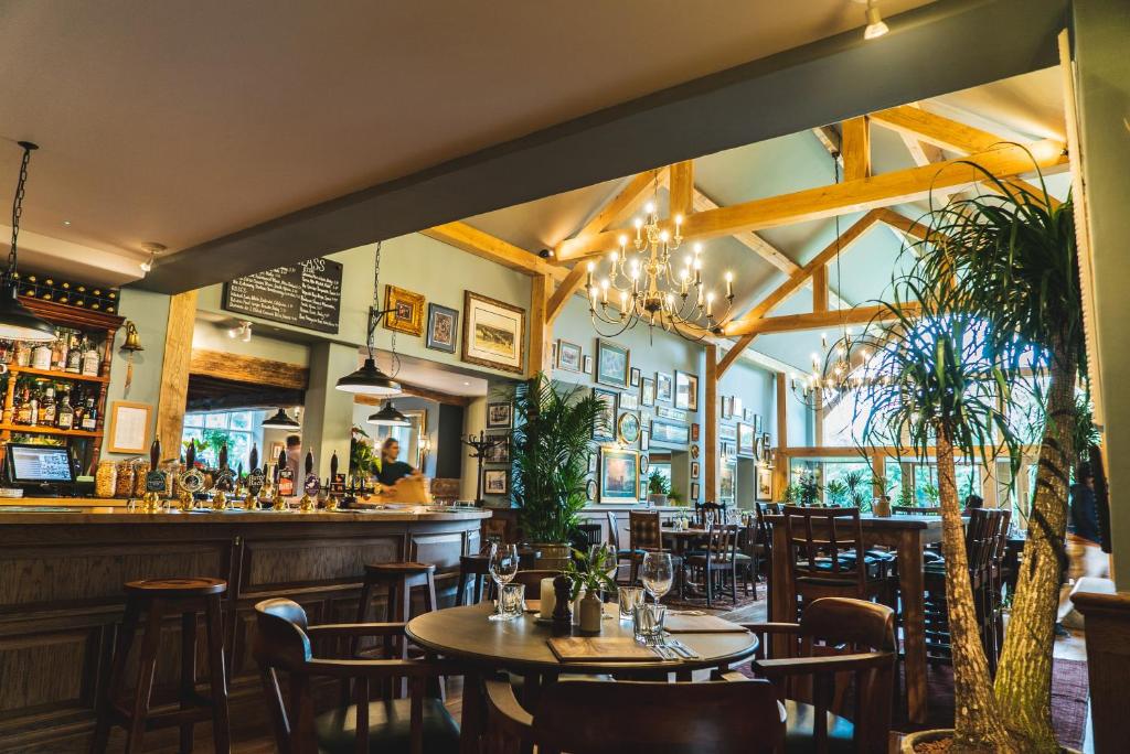 un restaurante con mesas y sillas y un bar en Arrow Mill- Brunning and Price en Alcester