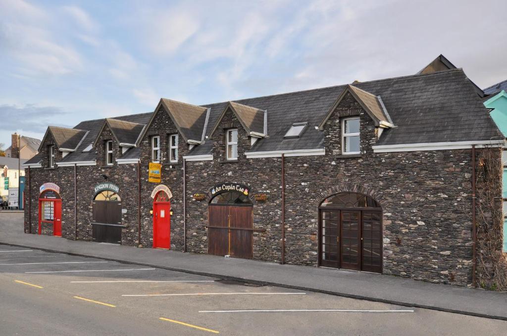a brick building with red doors on a street at The Quayside B&B in Dingle