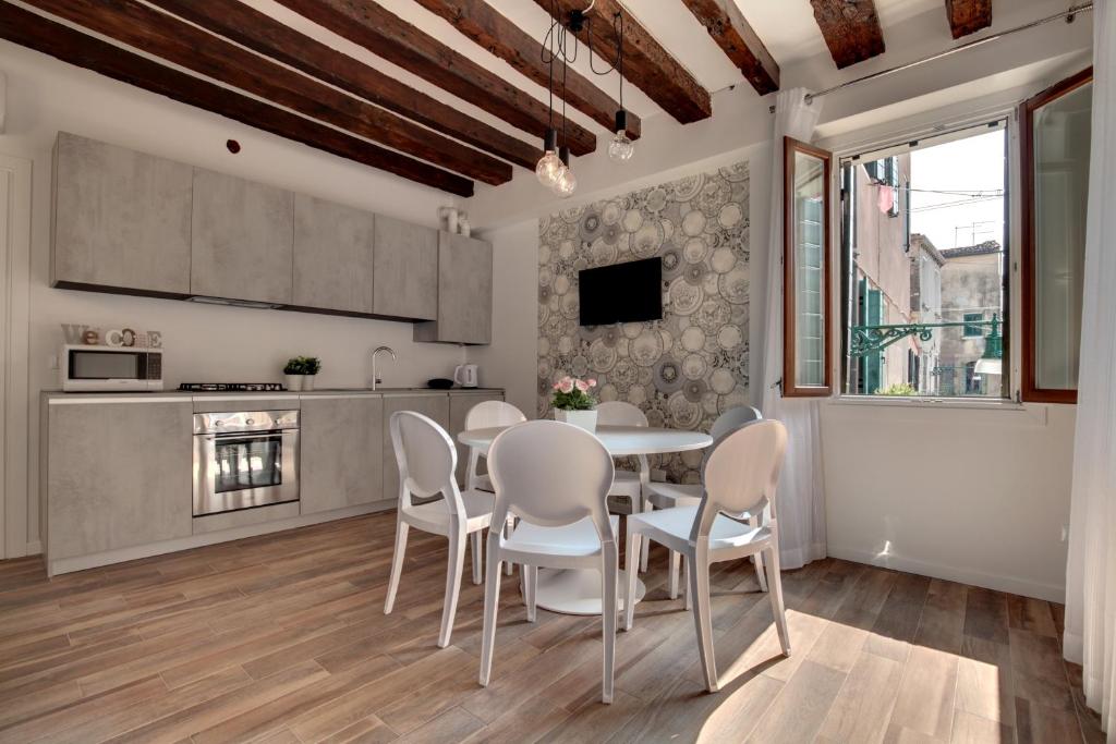 威尼斯的住宿－Castello - Laguna Luxury Residence，厨房以及带桌椅的用餐室。