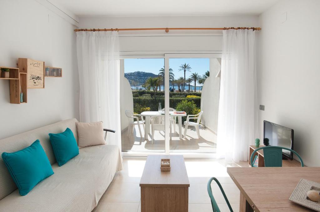 uma sala de estar com um sofá e uma mesa em Apartamento a pie de playa, climatizado y parking em Roses