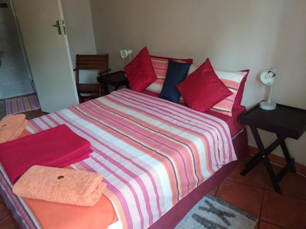 1 dormitorio con 1 cama con manta a rayas en 1010 Clifton bnb, en Centurion