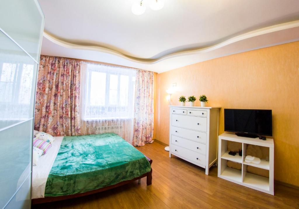 オムスクにあるRENT-сервис Apartments on Mayakovskogo 20のベッドルーム1室(ベッド1台、ドレッサー、テレビ付)