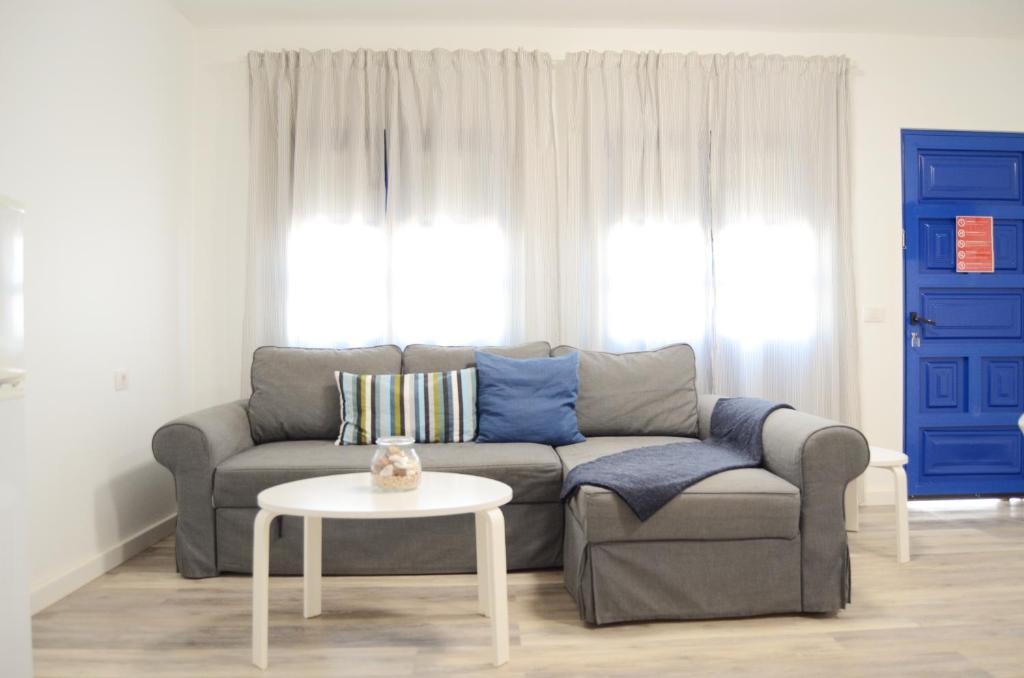 sala de estar con sofá y mesa en Apartamentos El Marinero - Iglesia, en Caleta de Sebo
