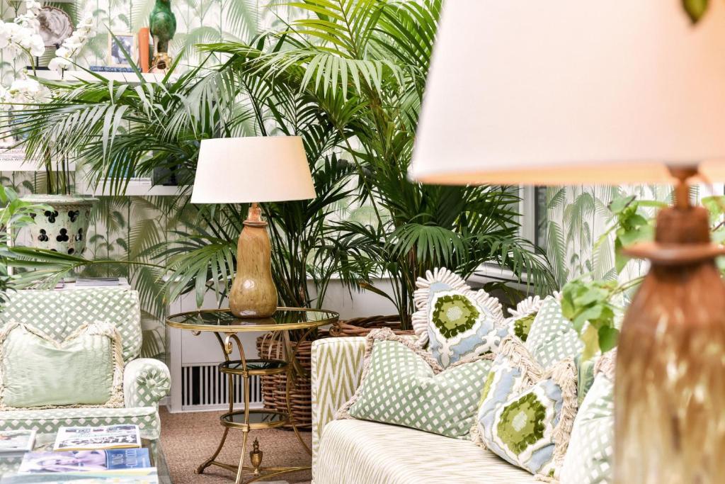 a living room with a couch and plants at Hotel Van Cleef in Bruges