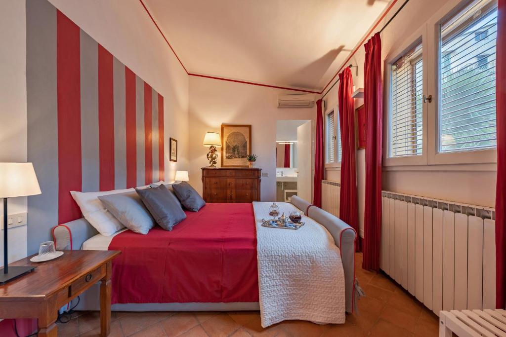 a bedroom with a red bed and a table at Drom Florence Rooms & Apartments in Florence