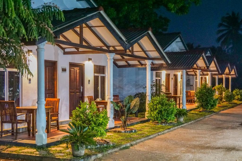 a house with a table and chairs in front of it at Luna Beach Hotel in Nilaveli