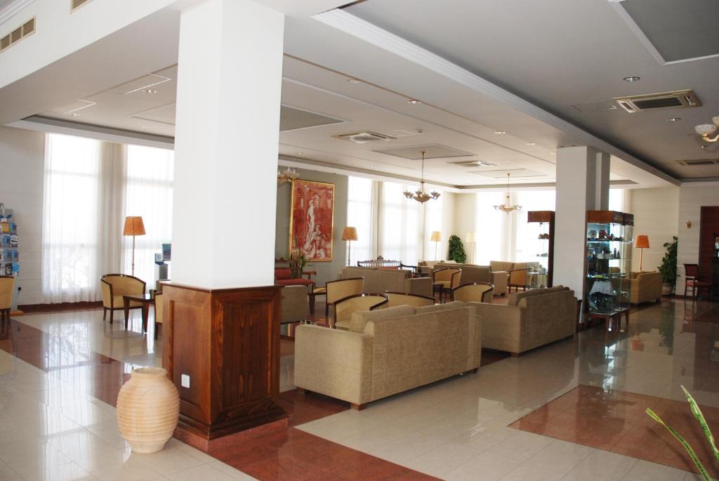 a lobby with couches and chairs in a building at Aktea Beach Village in Ayia Napa