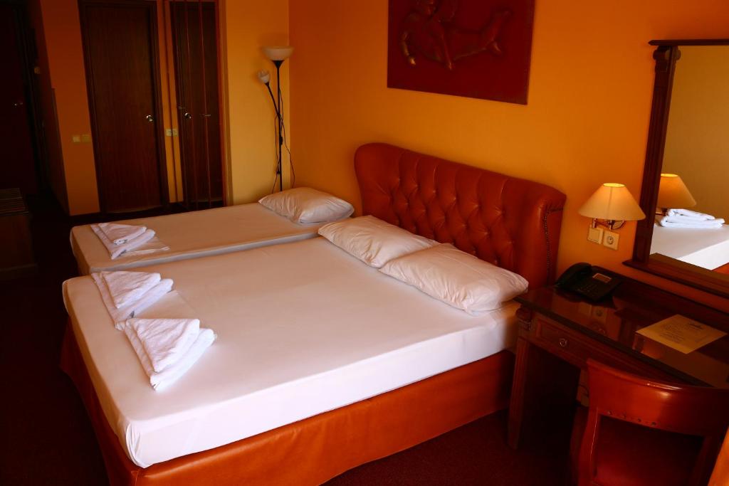 a bed with two pillows on it in a room at Galini Palace in Athens