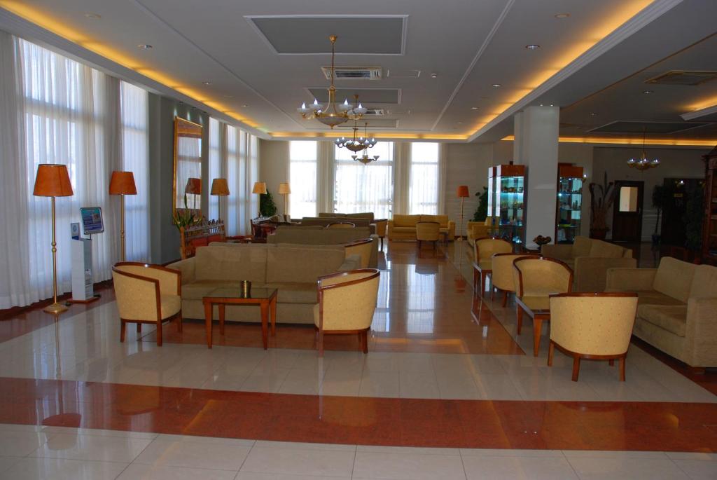 a lobby with couches and chairs in a building at Aktea Beach Village in Ayia Napa