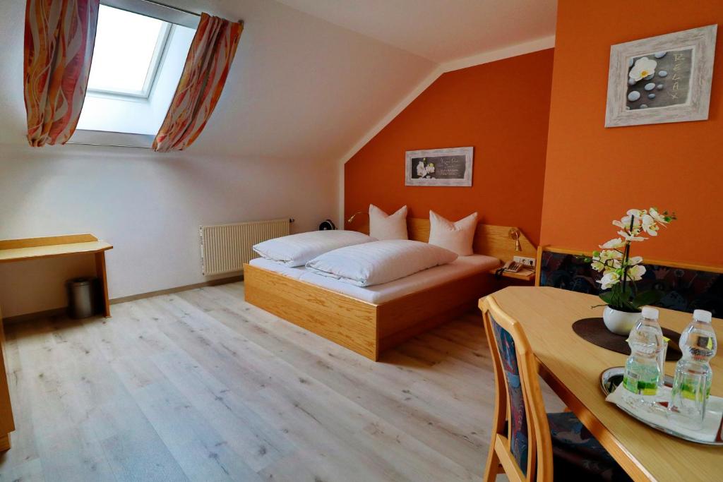 Dormitorio pequeño con cama y mesa en Gasthof Huber, en Wels