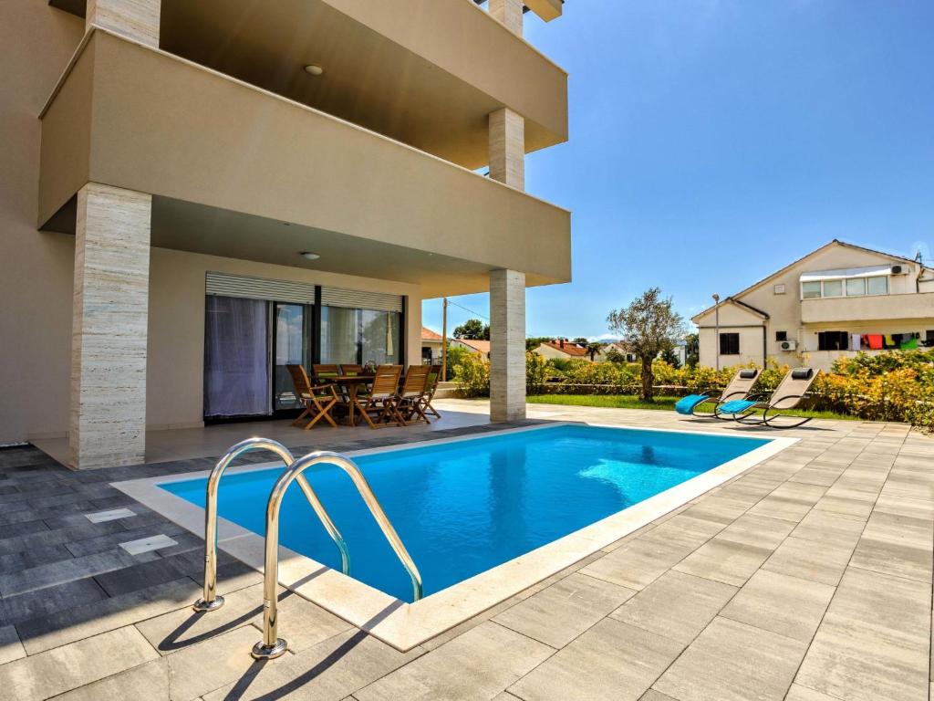 a swimming pool in the backyard of a house at Apartment ViD by Interhome in Vantačići