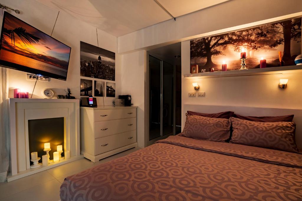 a bedroom with a large bed and a fireplace at Club Replay Apartment in Bophut 
