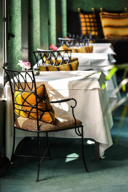 a row of tables with yellow pillows on them at Hotel Van Cleef in Bruges