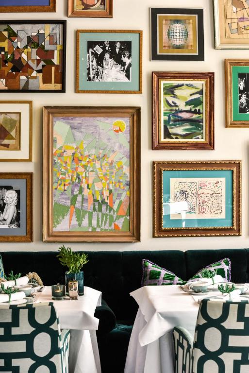 a dining room with two tables and pictures on the wall at Hotel Van Cleef in Bruges