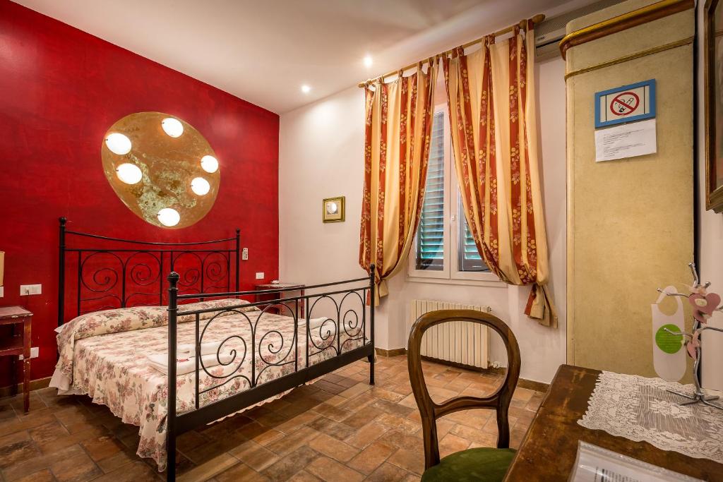 a bedroom with a bed and a red wall at Soggiorno Sogna Firenze in Florence