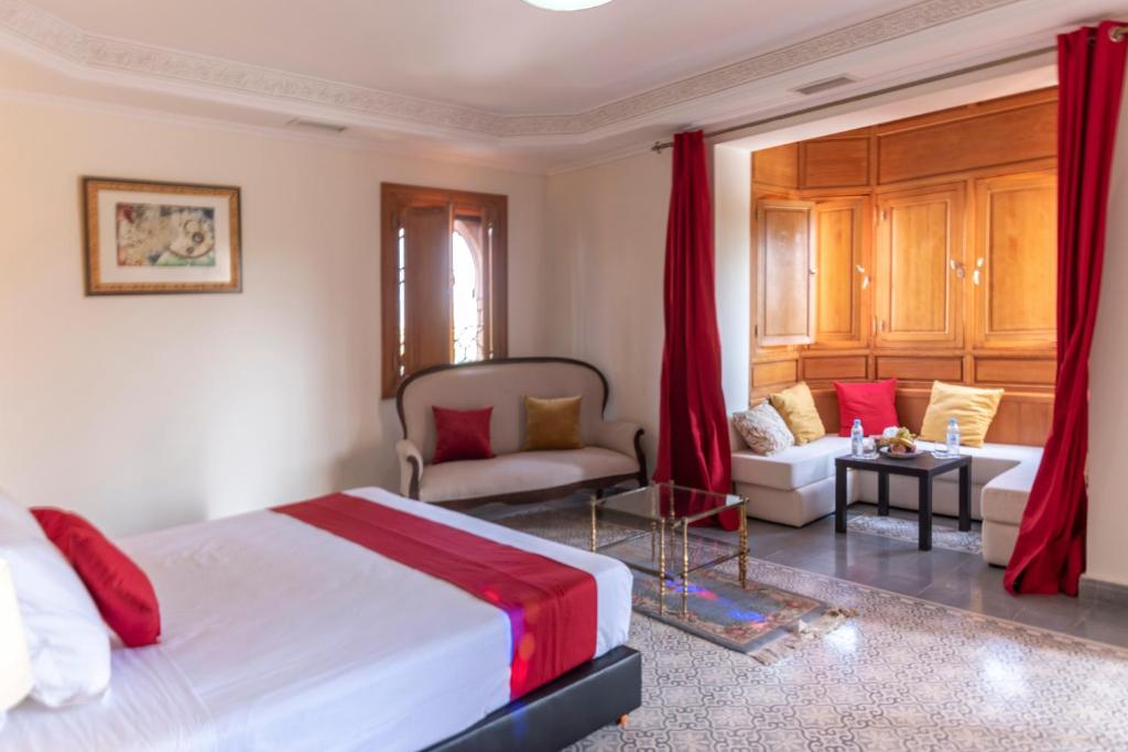a bedroom with a bed and a living room at Hôtel Riad Airport Marrakech in Marrakech