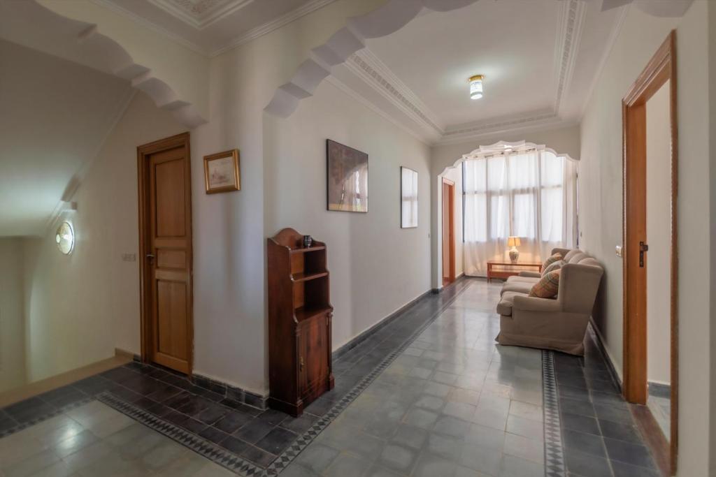 a living room with a couch and a chair at Hôtel Riad Airport Marrakech in Marrakech