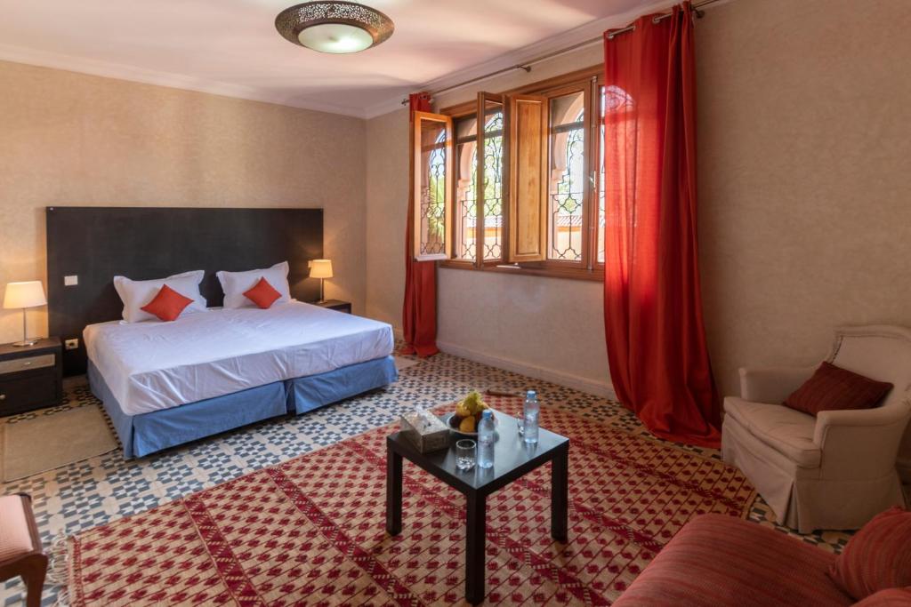 a hotel room with a bed and a table at Hôtel Riad Airport Marrakech in Marrakech