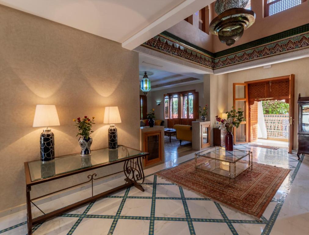 a living room with a table and a couch at Hôtel Riad Airport Marrakech in Marrakech