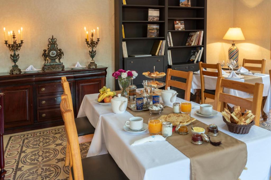 a dining room with two tables with food and drinks at Hôtel Riad Airport Marrakech in Marrakech