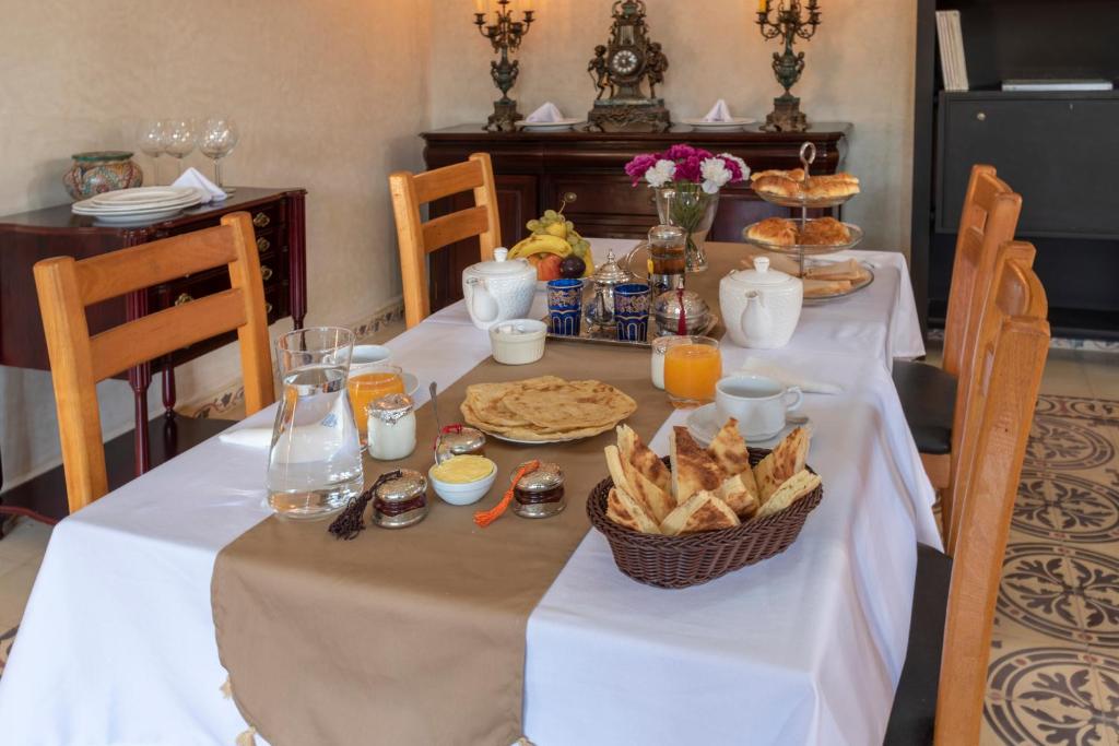 a table with a white table cloth with food on it at Hôtel Riad Airport Marrakech in Marrakech