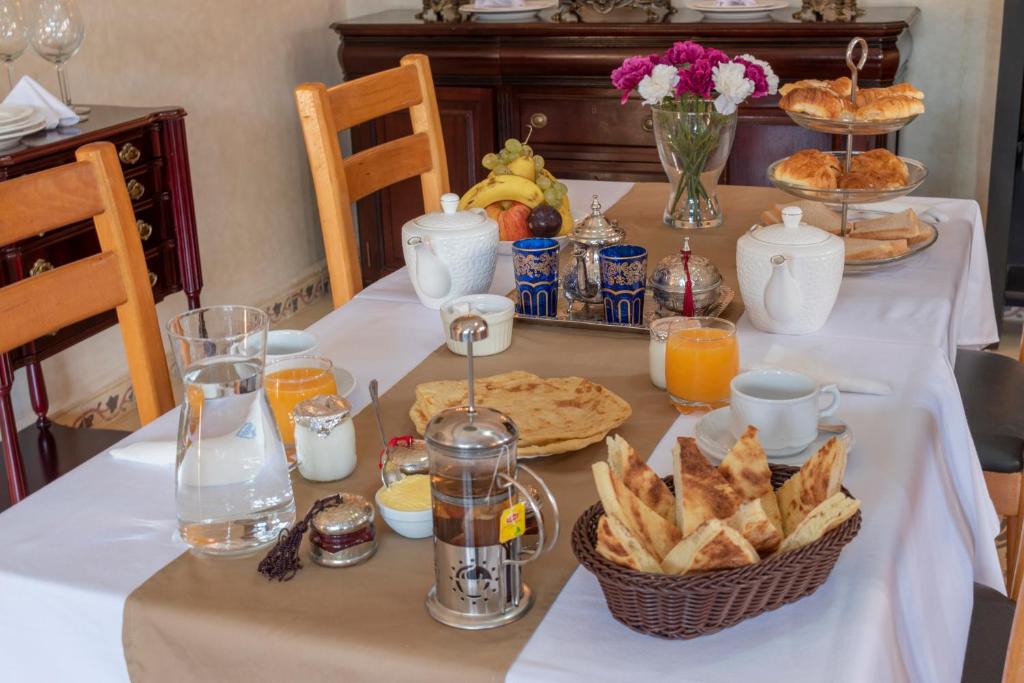 a table with a breakfast of bread and orange juice at Hôtel Riad Airport Marrakech in Marrakech