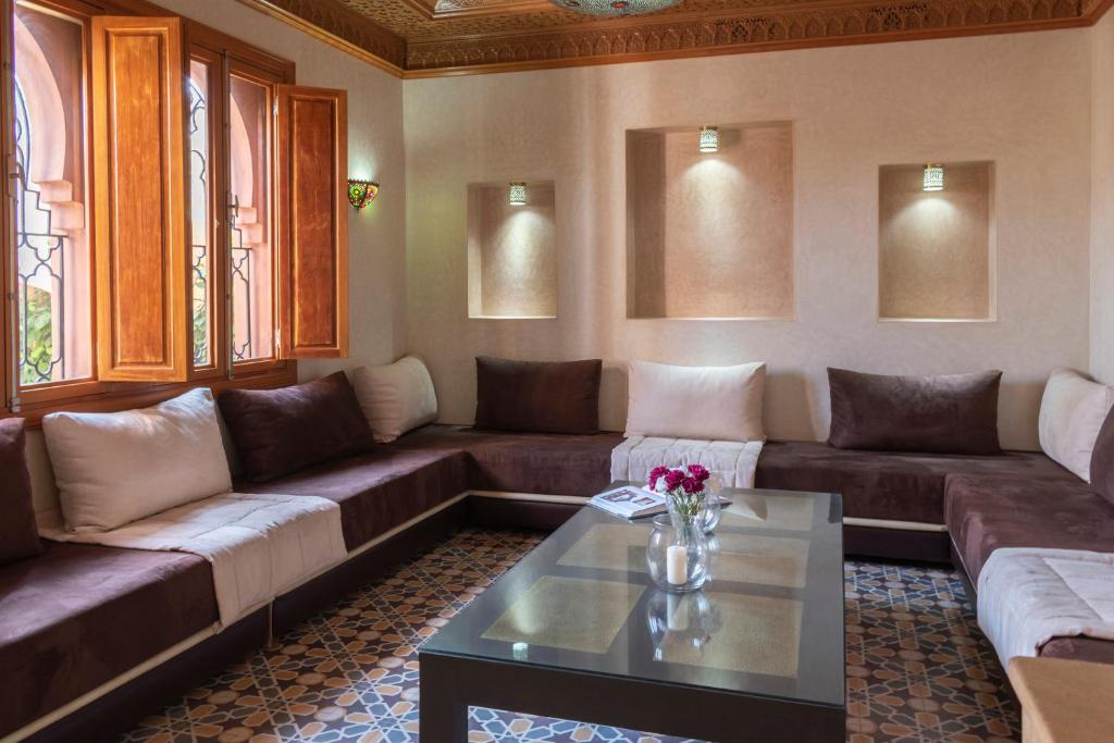 a living room with couches and a coffee table at Hôtel Riad Airport Marrakech in Marrakech