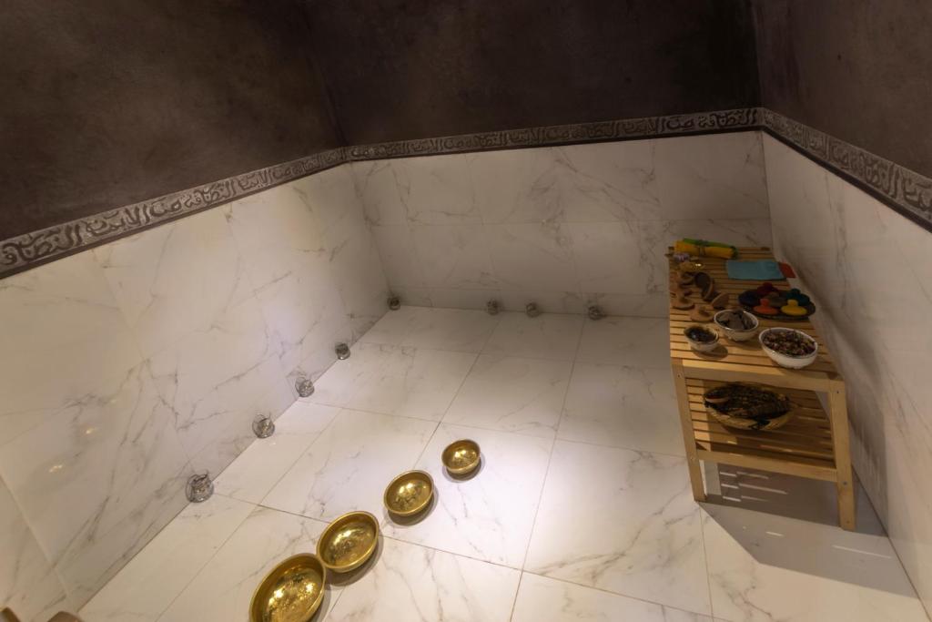 a room with gold items on a white tile floor at Hôtel Riad Airport Marrakech in Marrakech