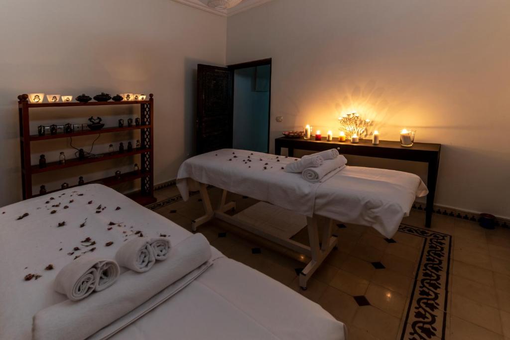a room with two beds and a table with candles at Hôtel Riad Airport Marrakech in Marrakech