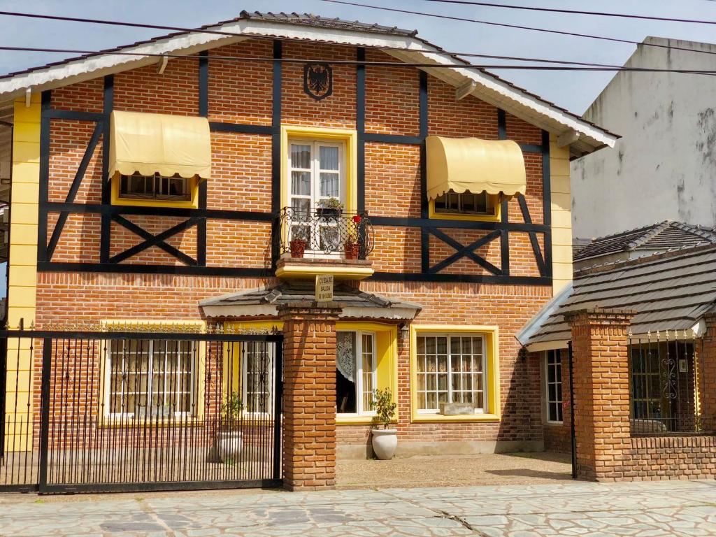 een rood bakstenen huis met een zwarte poort bij Hotel Sans Souci in Belén de Escobar