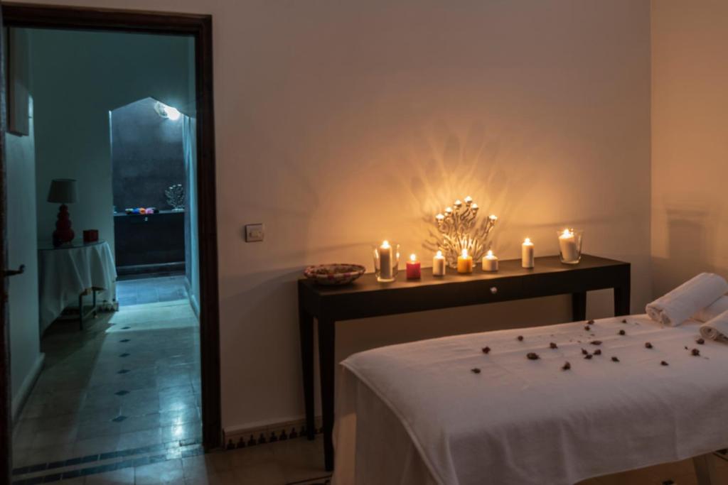 a room with a bed with candles on a table at Hôtel Riad Airport Marrakech in Marrakech