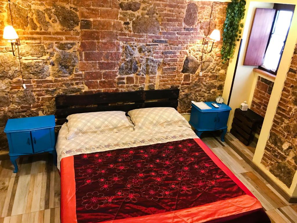 セッラ・サン・ブルーノにあるIL Vicolettoのベッドルーム1室(ベッド1台、青いナイトスタンド2台付)