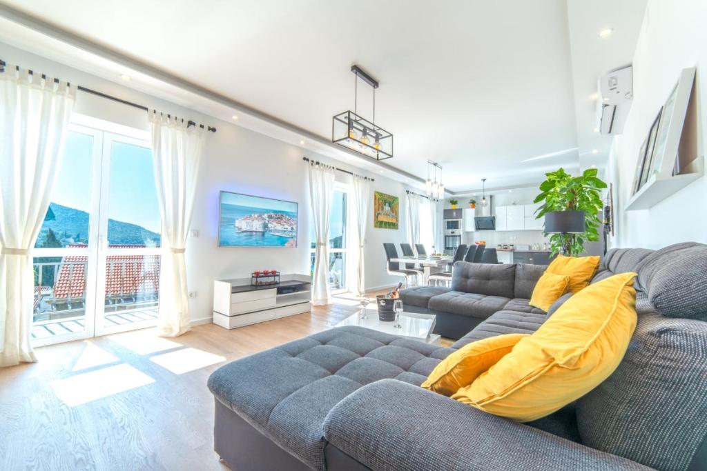 sala de estar con sofá gris y almohadas amarillas en Luxury 5* Apartment by Guide & Sleep en Zaton