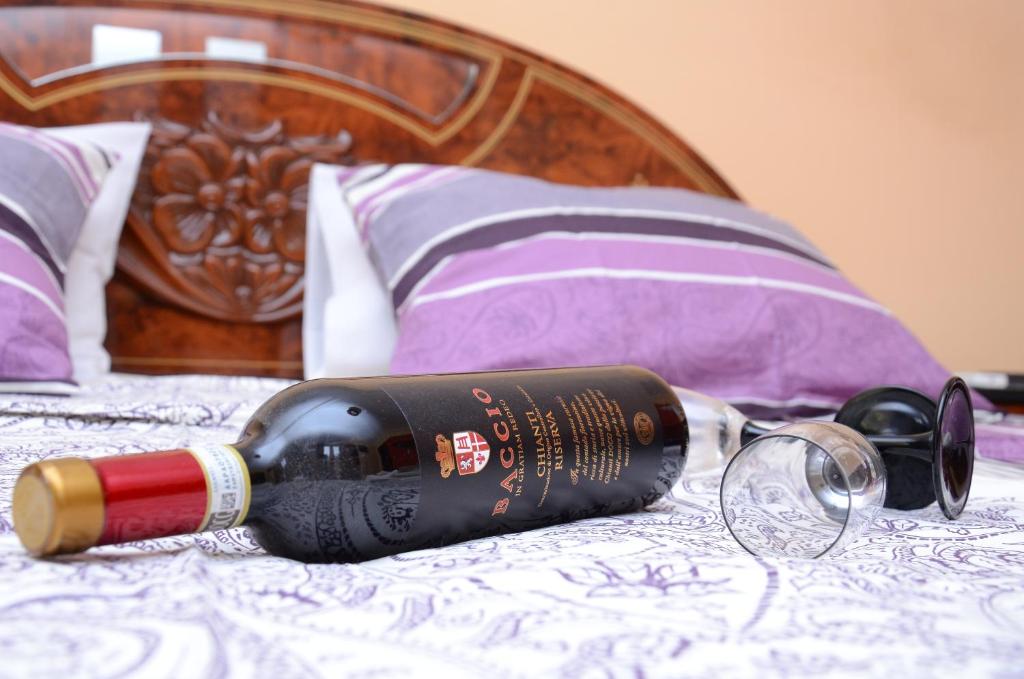 a bottle of wine sitting on top of a bed at STARA ČARŠIJA Restoran&Hostel in Ćuprija