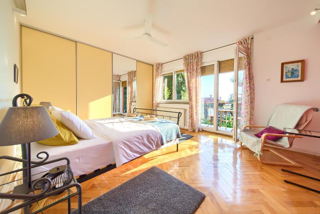 a bedroom with a bed and a chair at Feeling good Apartment in Rijeka