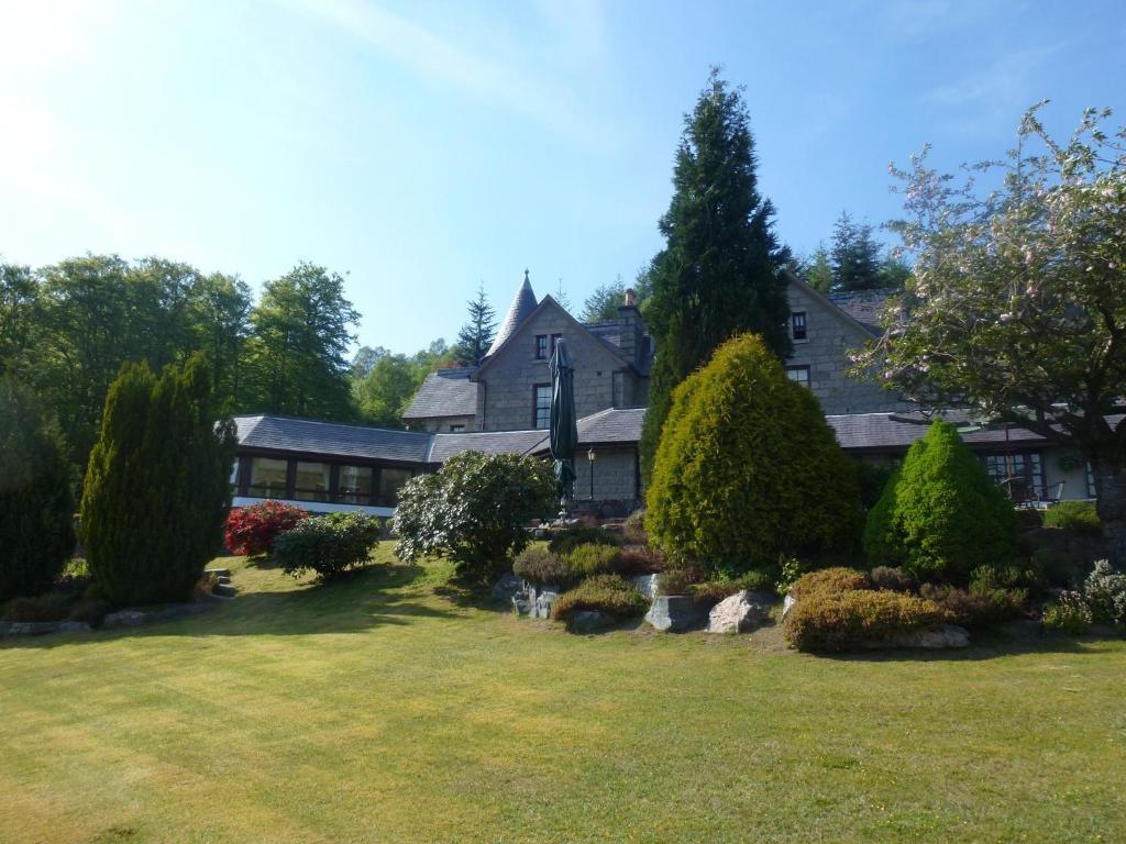 
a large house with a tree in front of it at Glenspean Lodge Hotel in Roybridge
