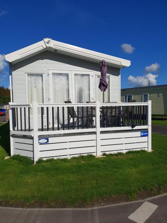 a white house with a white fence and a deck at Kent Getaways in Westgate-on-Sea