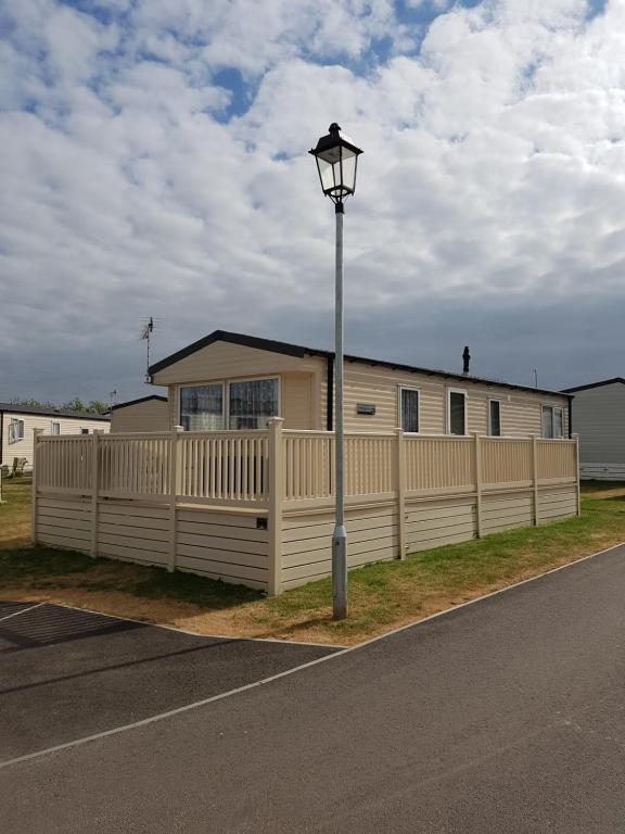 a house with a white fence and a street light at Kent Getaways in Westgate-on-Sea