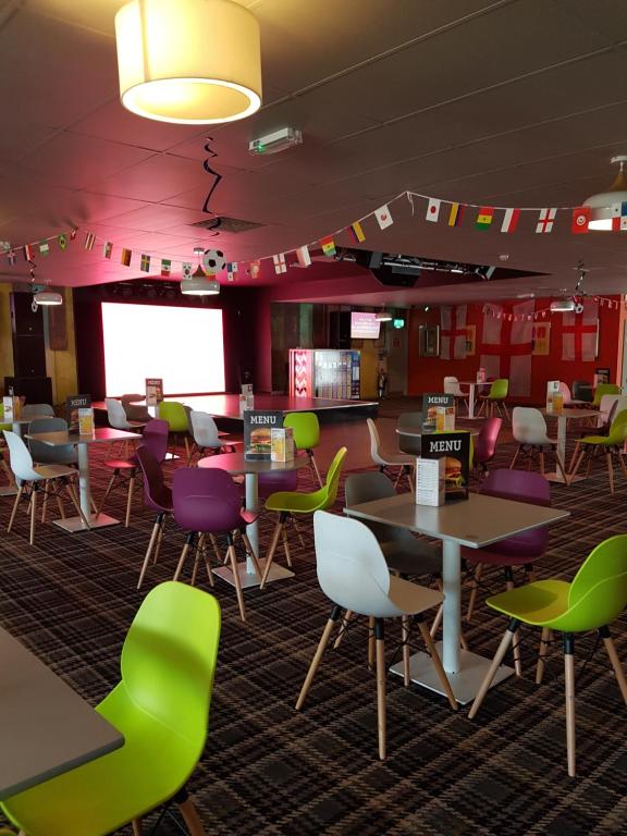 a dining room with colorful chairs and tables at Kent Getaways in Westgate-on-Sea