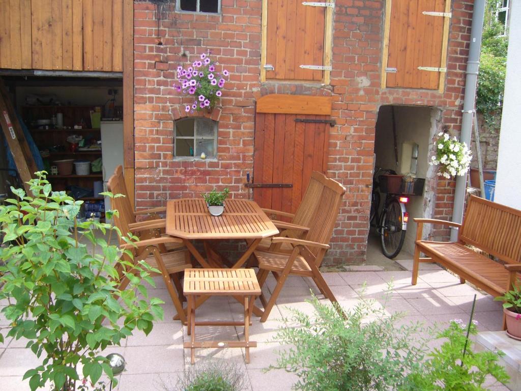 einen Holztisch und Stühle auf einer Terrasse in der Unterkunft Ferienwohnung "Lützowhof" in Lübeck