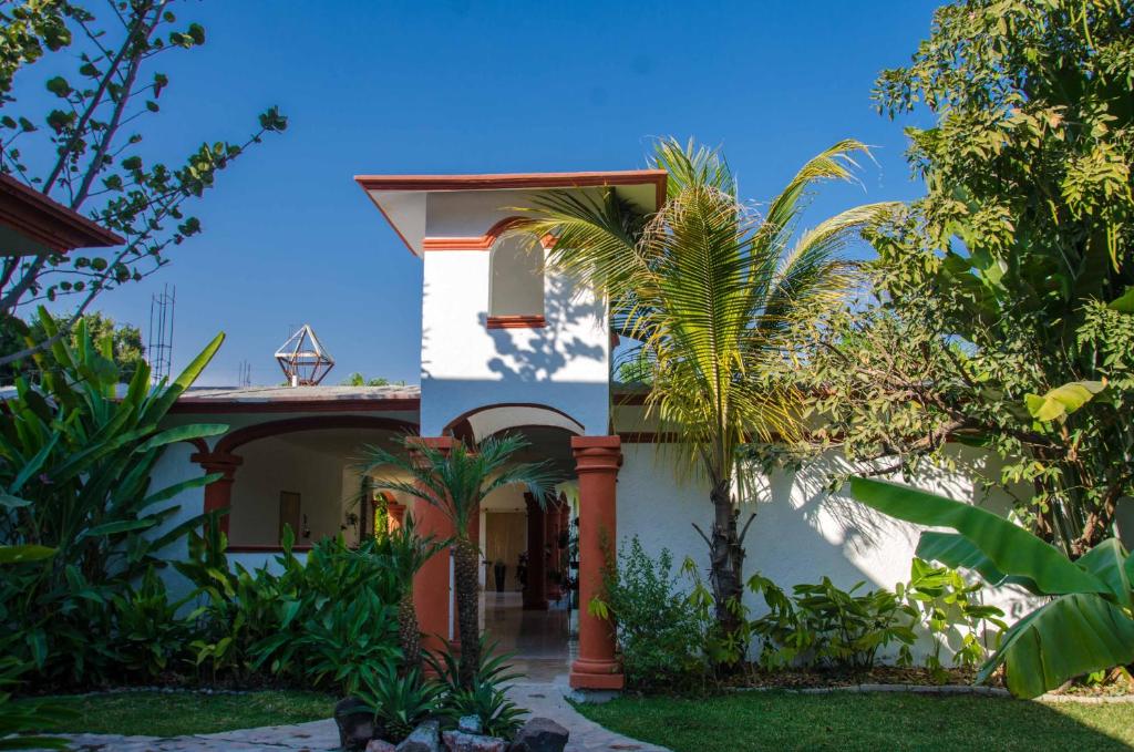 a house with a palm tree in front of it at Tonantzincalli SPA Prehispanico in Chiconcuac